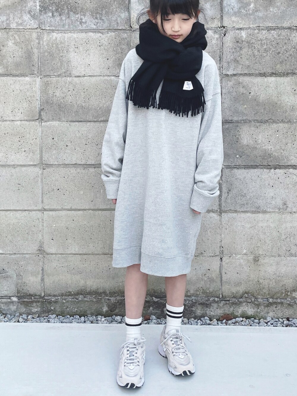ベージュ系のスニーカー、グレー系のパーカー、ブラック系のストール/ショールを着用したキッズの冬コーディネートの3枚目の写真