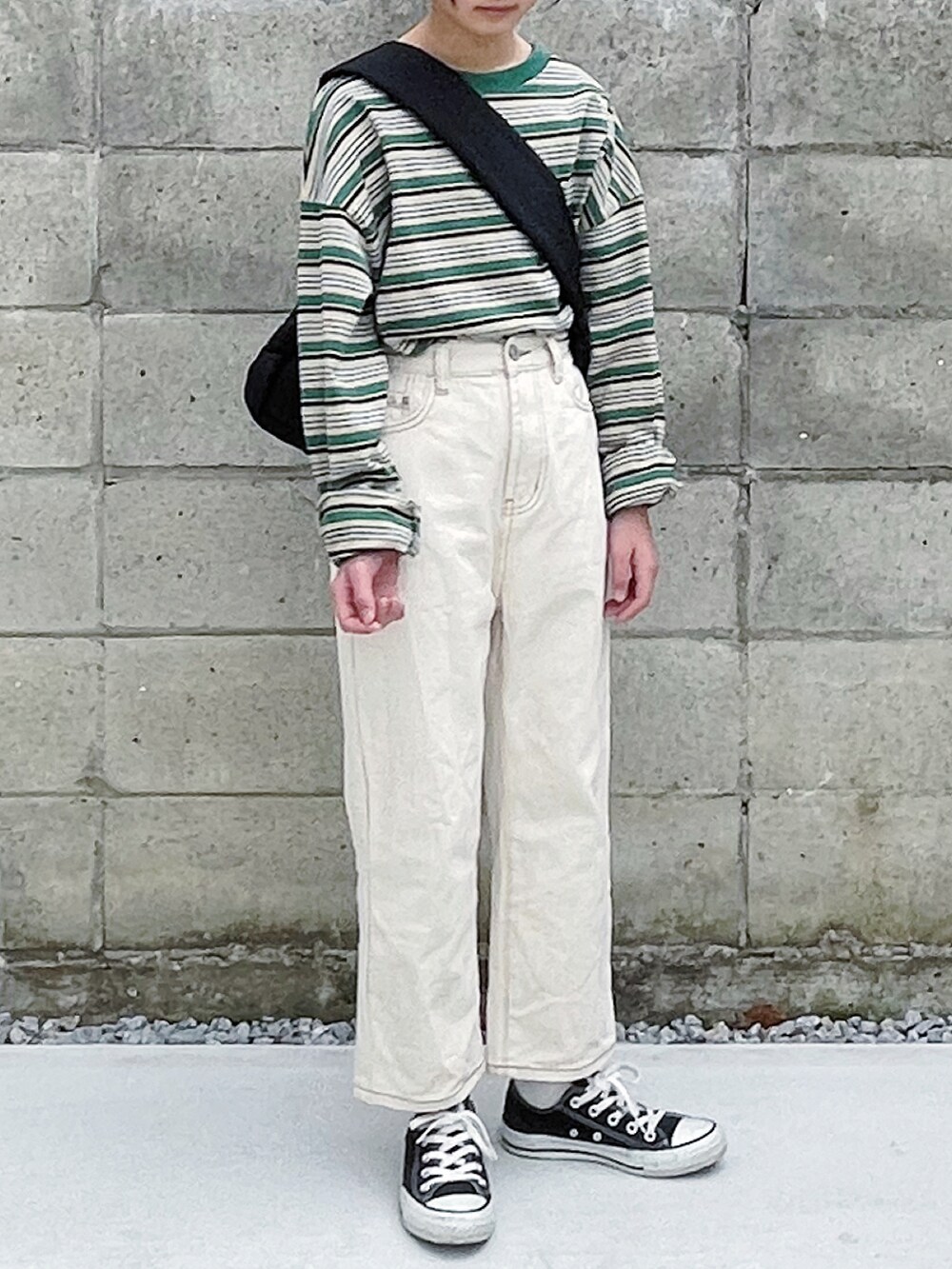 グリーン系のTシャツ/カットソー、ベージュ系のデニムパンツ、ブラック系のスニーカーを着用したキッズの冬コーディネートの2枚目の写真