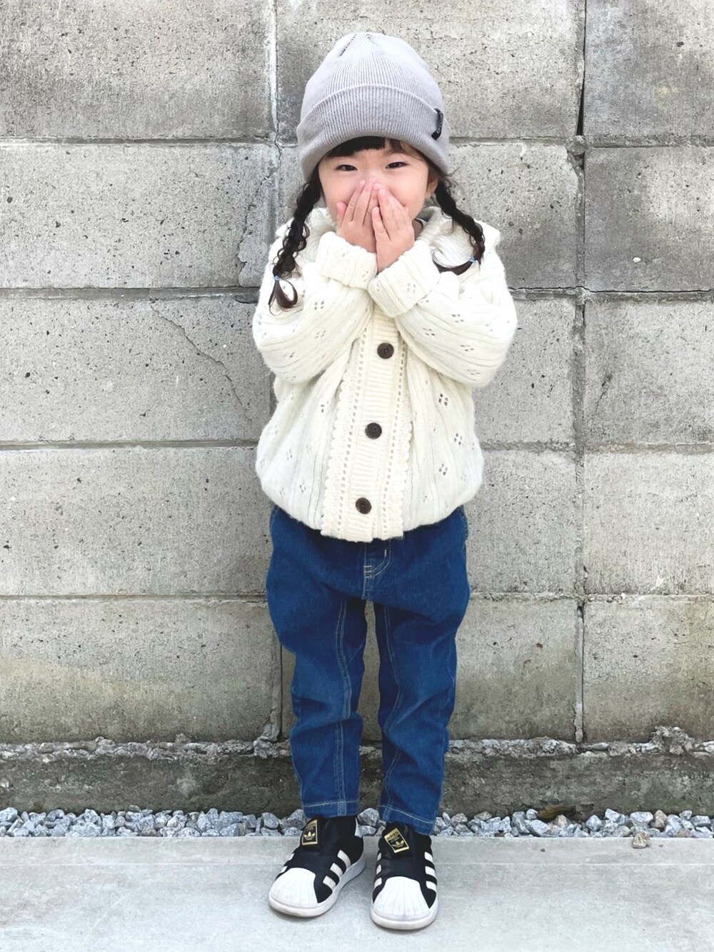 ホワイト系のニット/セーター、ブルー系のデニムパンツ、ブラック系のスニーカーを着用したキッズの春コーディネートの2枚目の写真