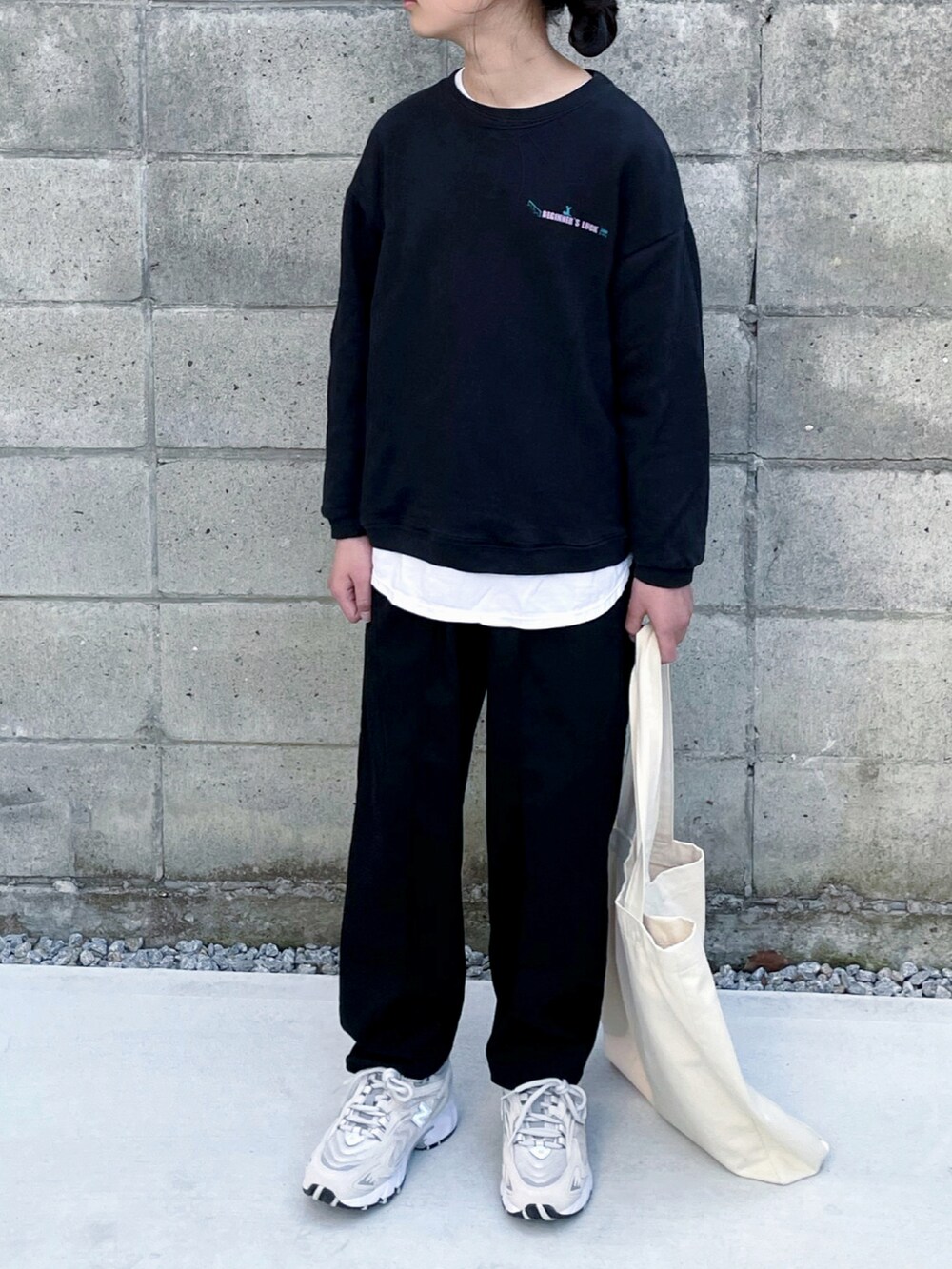 ベージュ系のスニーカー、ブラック系のその他パンツ、ホワイト系のトートバッグを着用したキッズの冬コーディネートの3枚目の写真