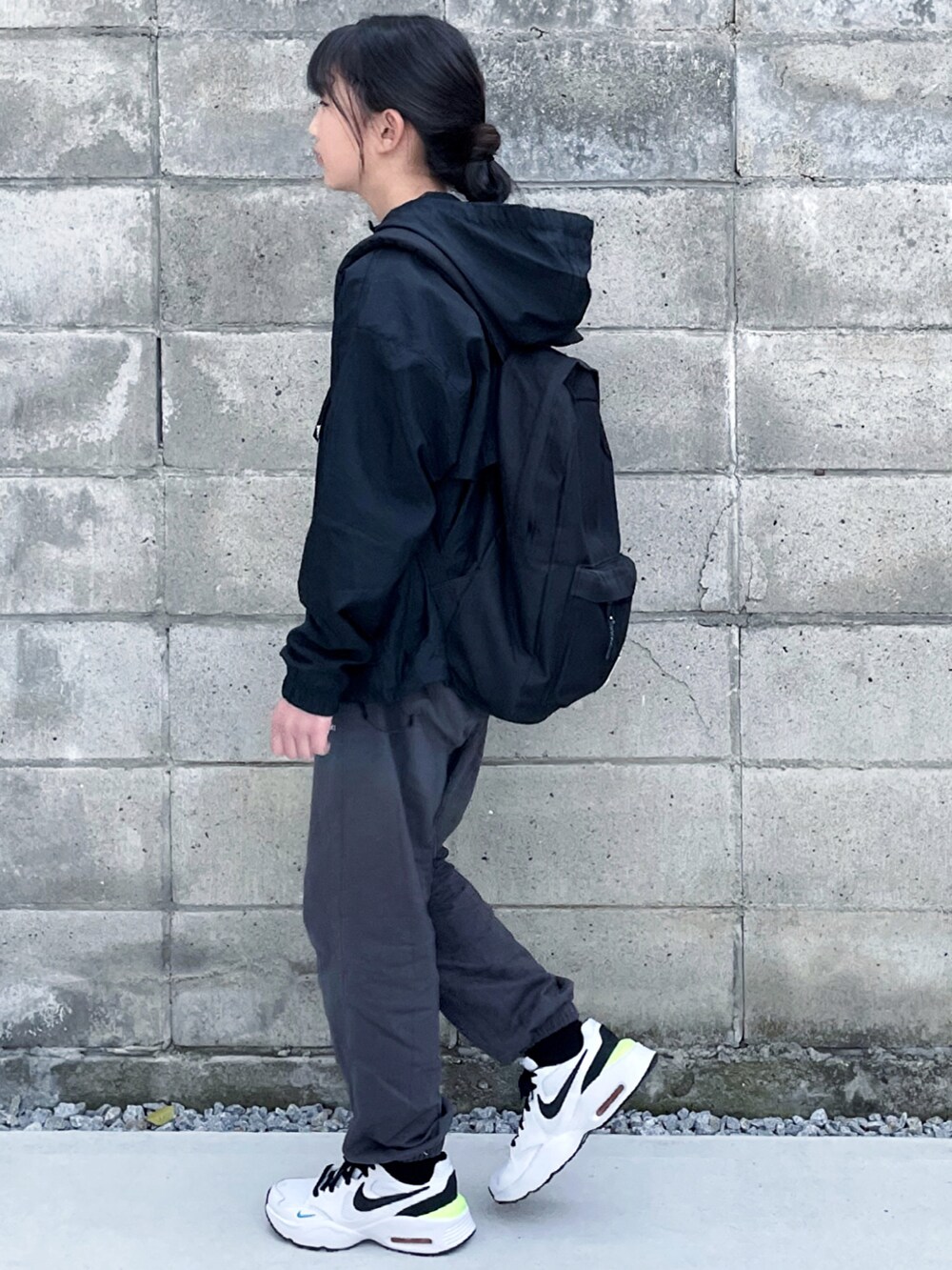 ブラック系のナイロンジャケット、グレー系のスウェットパンツ、ホワイト系のスニーカーを着用したキッズの春コーディネートの3枚目の写真