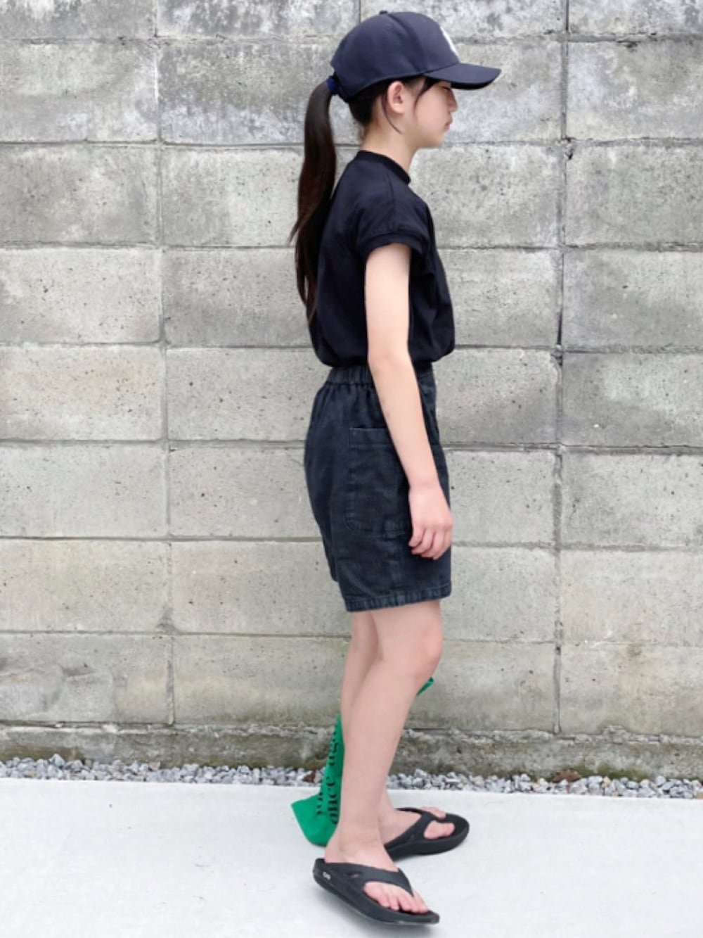 ブラック系のデニムパンツ、ブラック系のTシャツ/カットソー、ブラック系のサンダルを着用したキッズの夏コーディネートの2枚目の写真