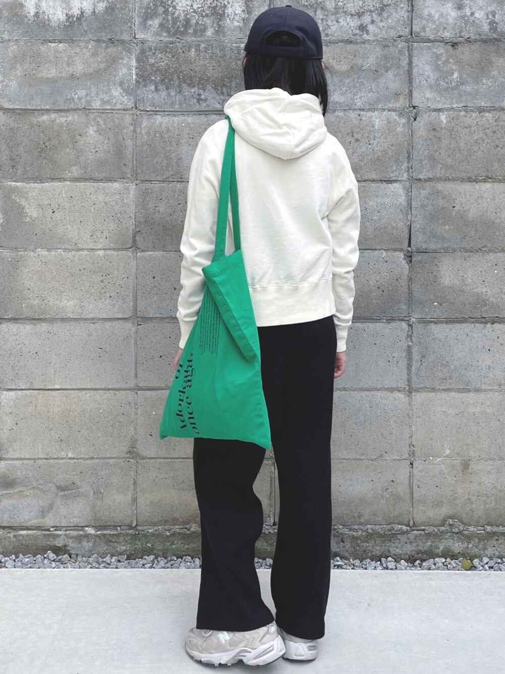 グリーン系のエコバッグ/サブバッグ、ベージュ系のスニーカー、ブルー系のキャップを着用したキッズの秋コーディネートの2枚目の写真