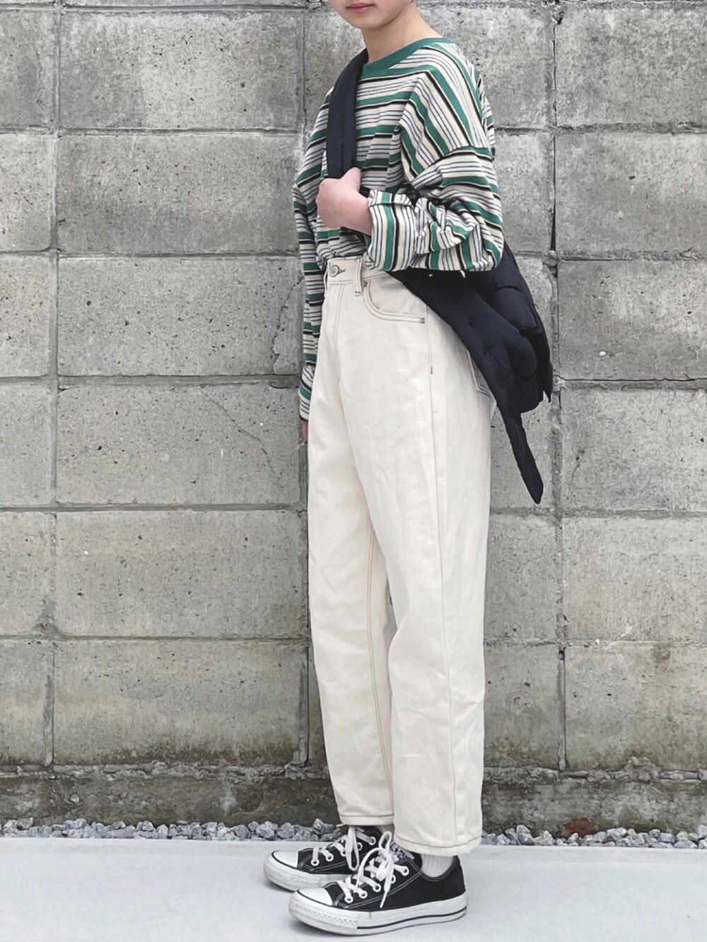 グリーン系のTシャツ/カットソー、ベージュ系のデニムパンツ、ブラック系のスニーカーを着用したキッズの冬コーディネートの3枚目の写真