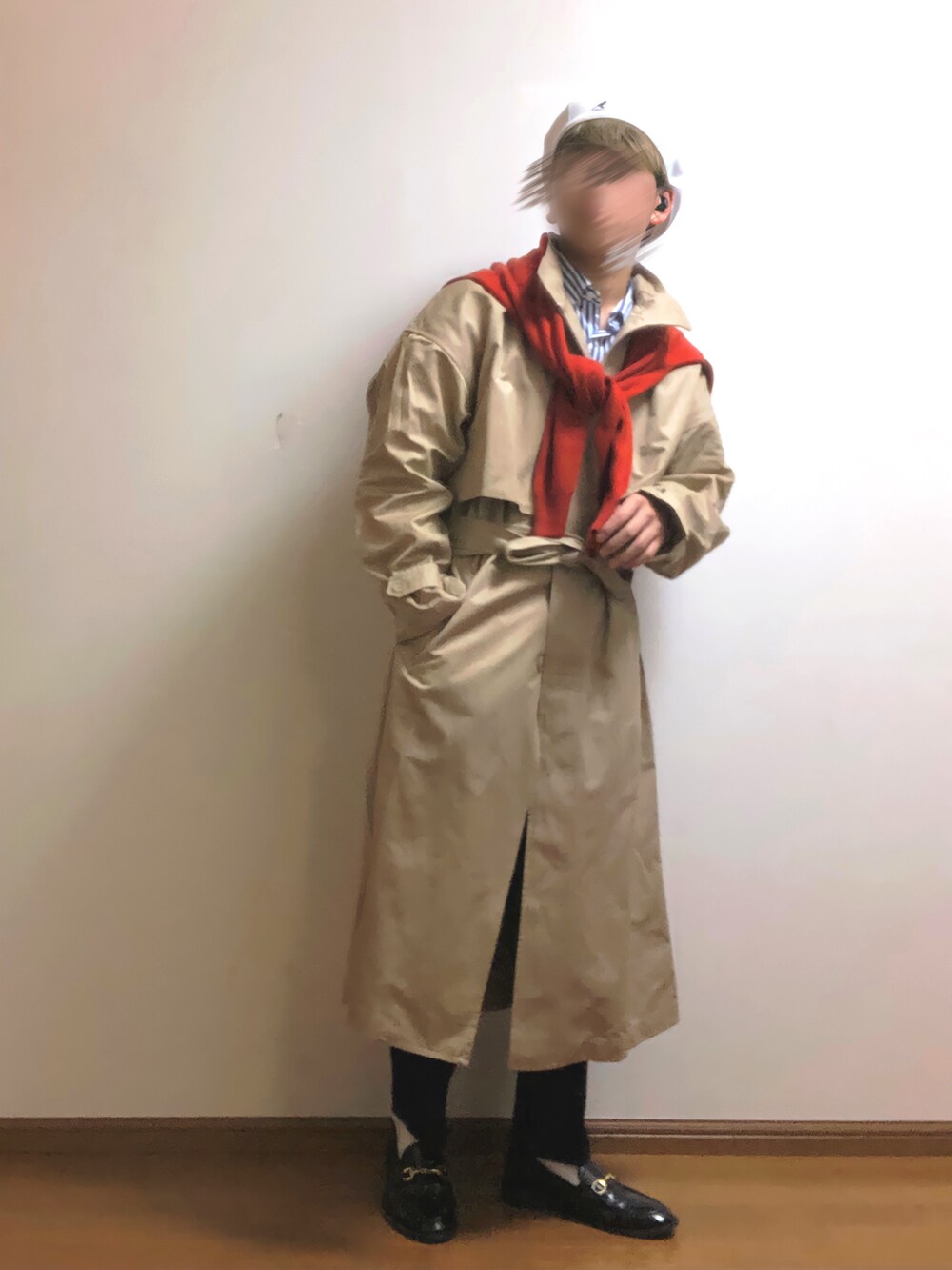 ベージュ系のトレンチコート、レッド系のニット/セーター、ブルー系のスラックスを着用したメンズの春コーディネートの3枚目の写真