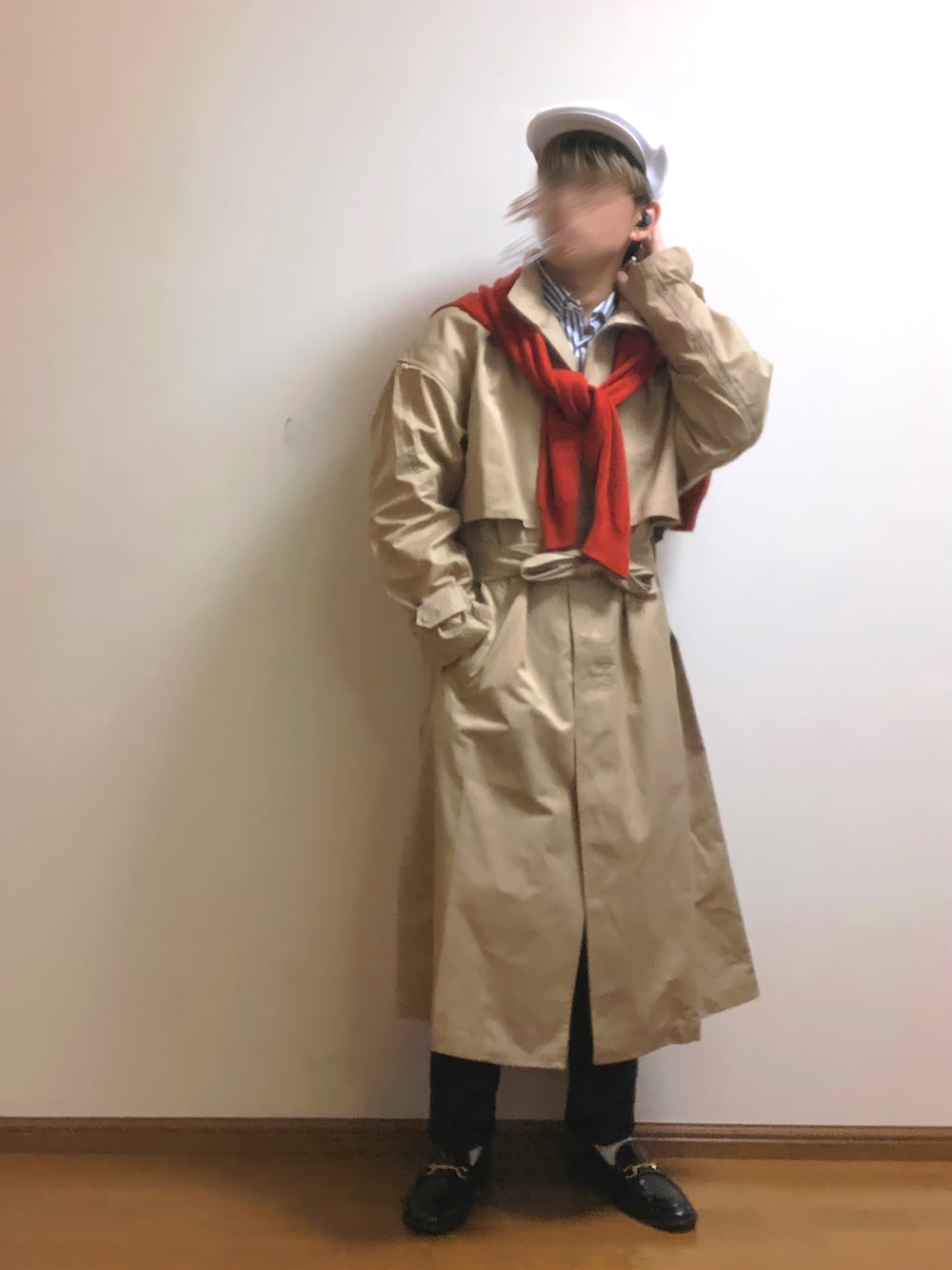 ベージュ系のトレンチコート、レッド系のニット/セーター、ブルー系のスラックスを着用したメンズの春コーディネートの2枚目の写真