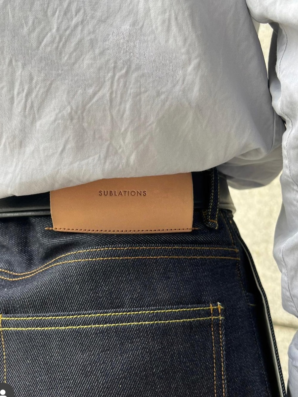 ブルー系のデニムパンツ、ブラック系のローファー、ブラック系のショルダーバッグを着用したメンズの春コーディネートの3枚目の写真