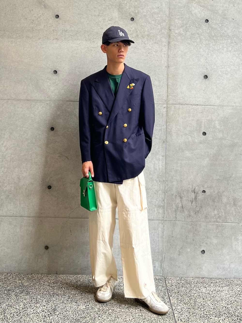 グリーン系のTシャツ/カットソー、グリーン系のショルダーバッグ、ホワイト系のカーゴパンツを着用したメンズの秋コーディネートの4枚目の写真