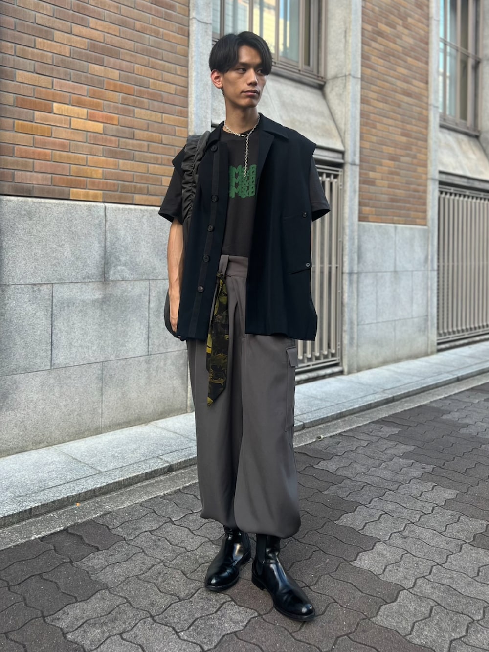 ブラック系のブーツ、グレー系のカーゴパンツ、ブラック系のベストを着用したメンズの夏コーディネートの2枚目の写真