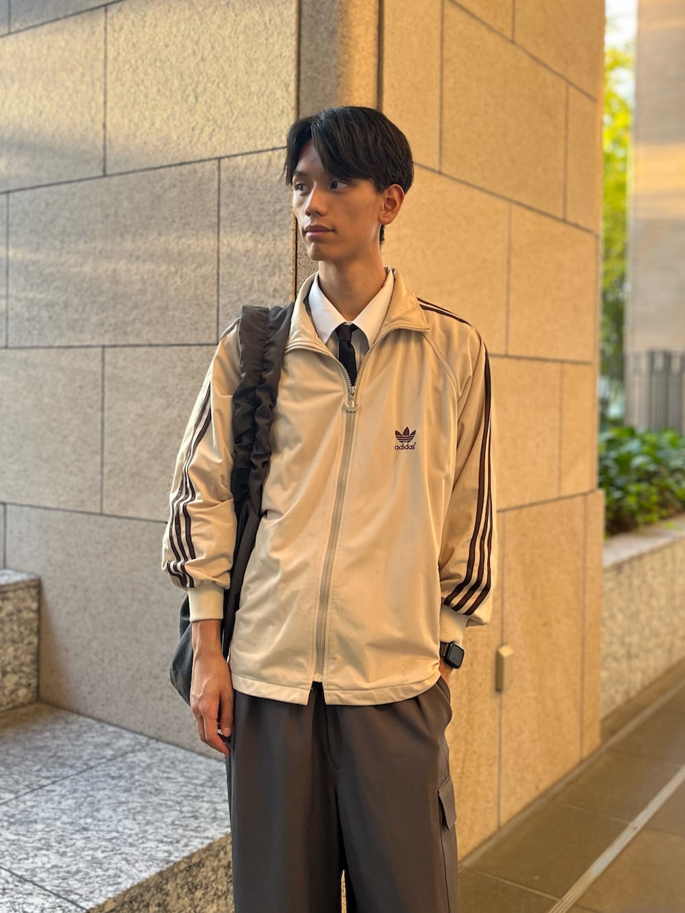 グレー系のカーゴパンツ、ベージュ系のジャージ、ブラック系のネクタイを着用したメンズの秋コーディネートの3枚目の写真