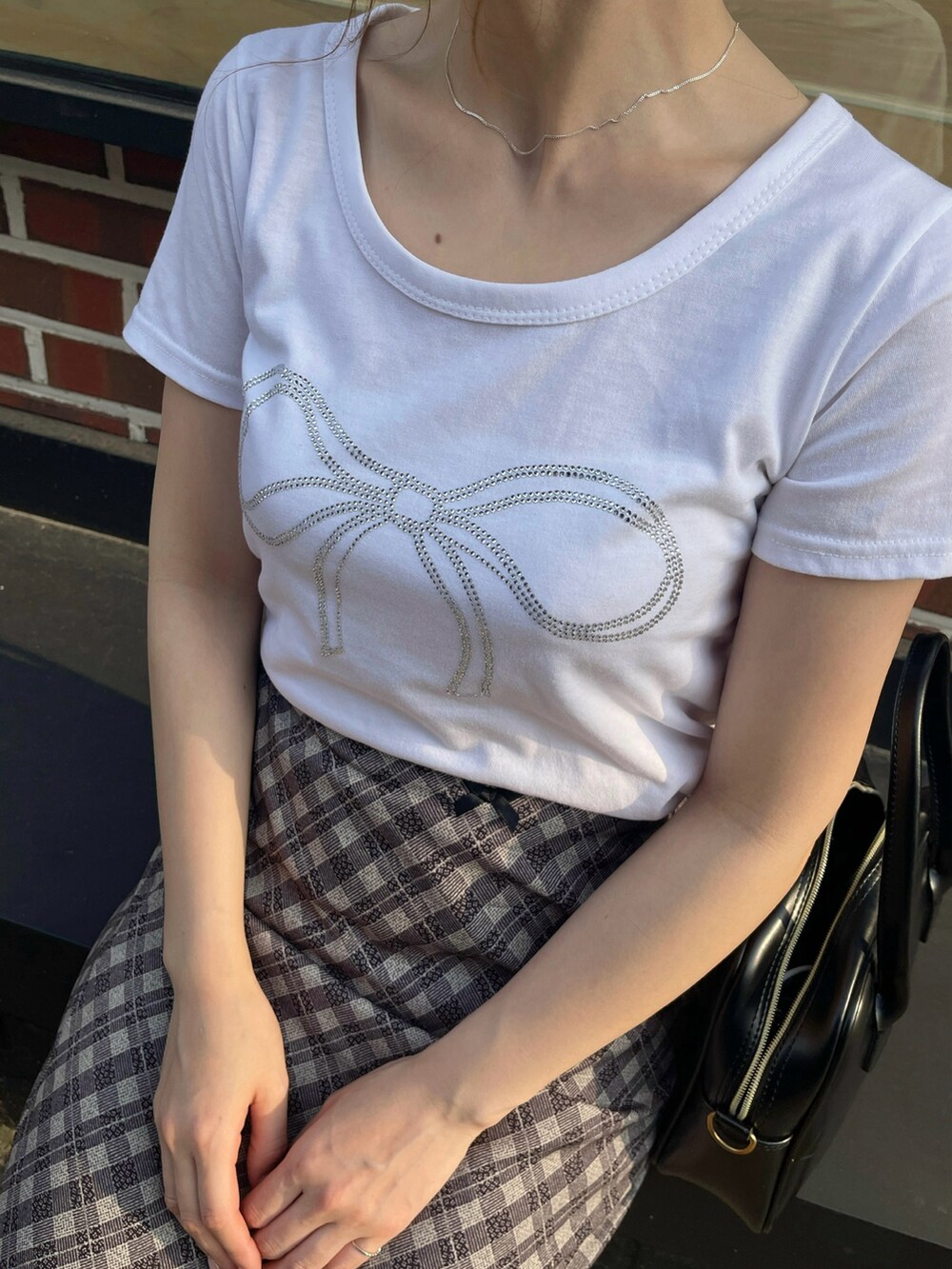ホワイト系のTシャツ/カットソー、ベージュ系のスカートを着用したレディースの夏コーディネートの3枚目の写真