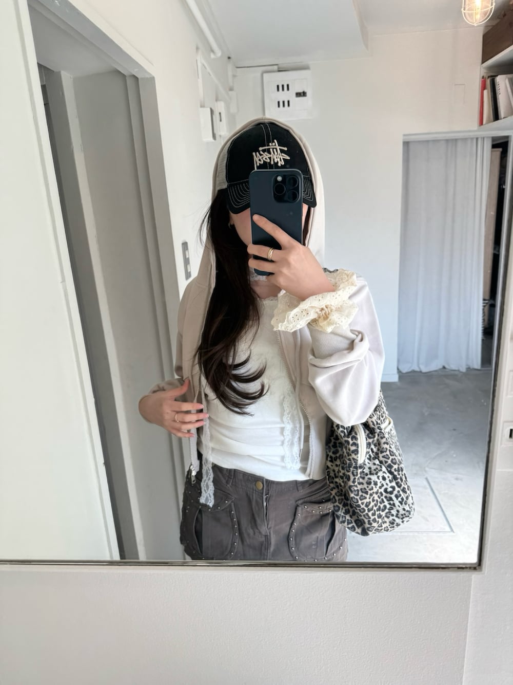 ホワイト系のトップス、ブラウン系のスカート、ベージュ系のパーカーを着用したレディースの春コーディネートの2枚目の写真