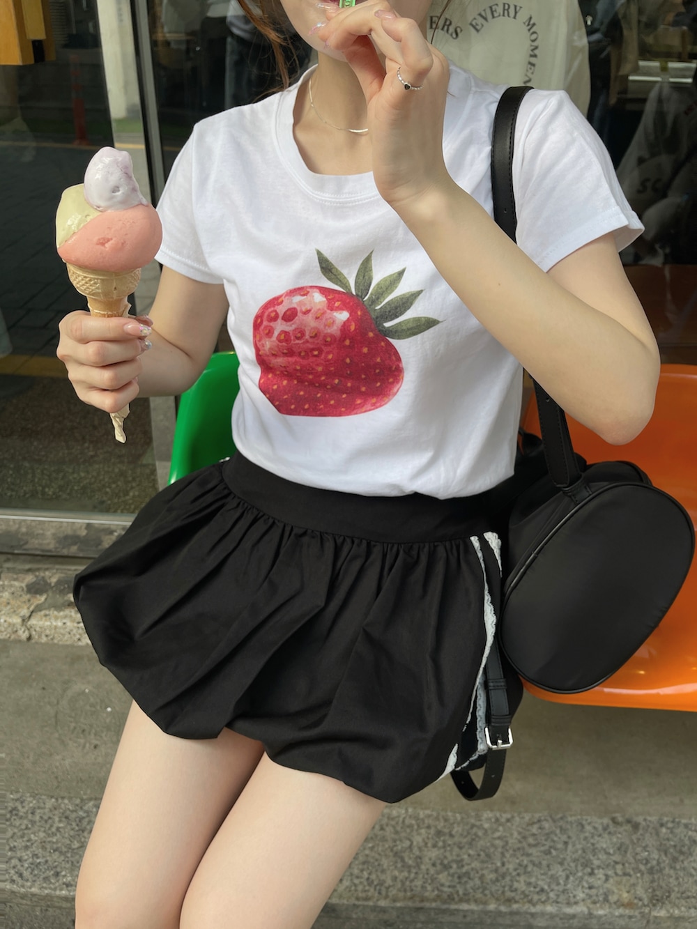 ホワイト系のTシャツ/カットソー、ブラック系のスカートを着用したレディースの夏コーディネートの2枚目の写真