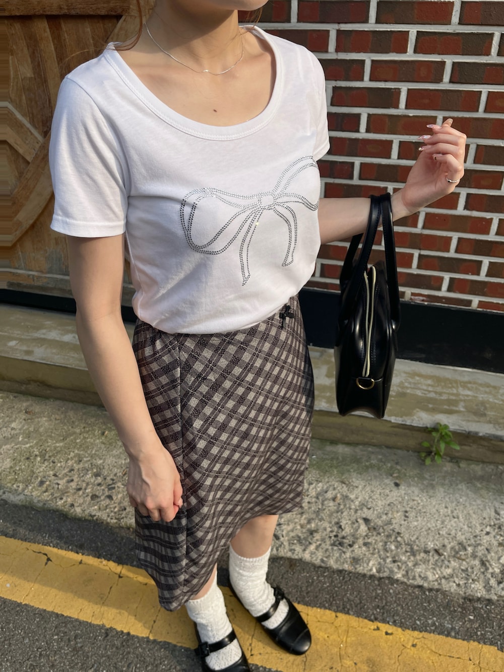 ホワイト系のTシャツ/カットソー、ベージュ系のスカートを着用したレディースの夏コーディネートの2枚目の写真