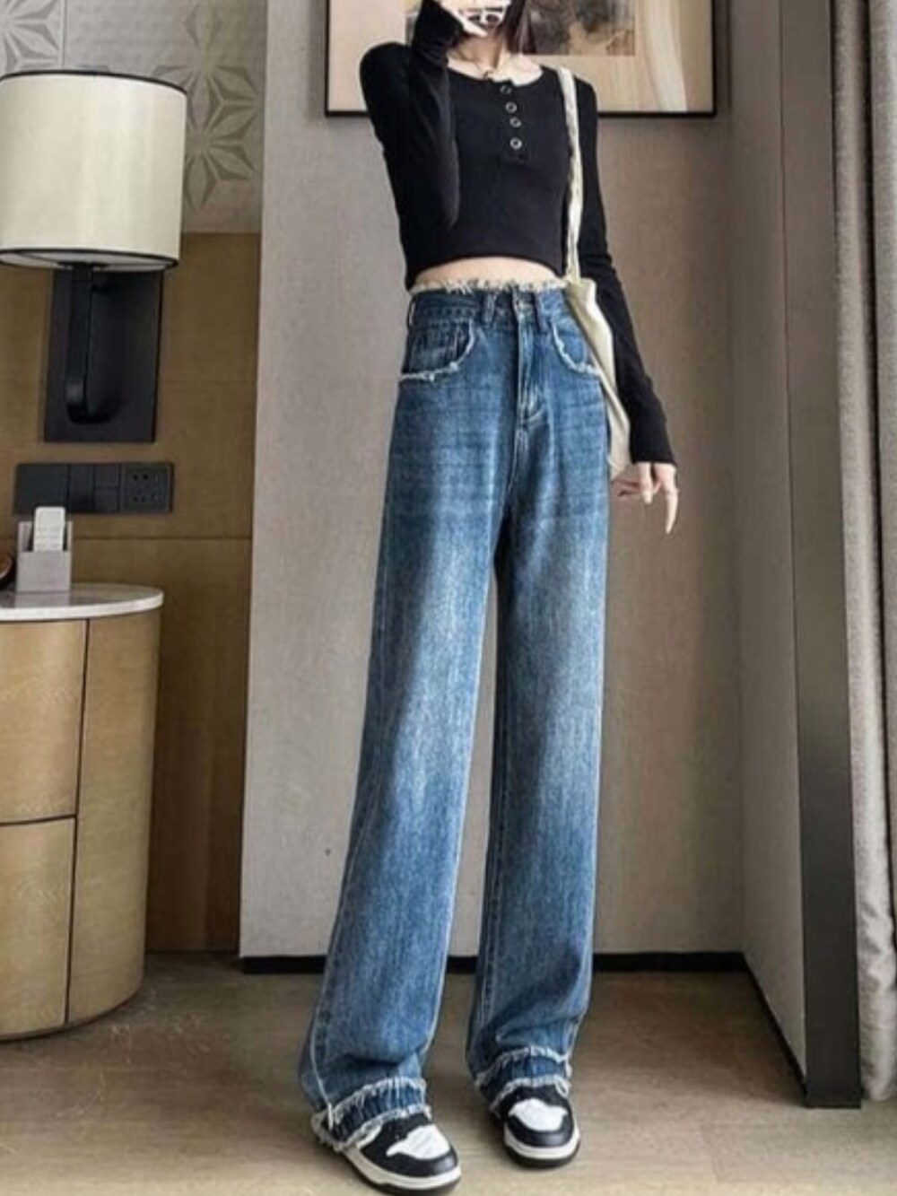 ブルー系のデニムパンツを着用したレディースの秋コーディネートの2枚目の写真