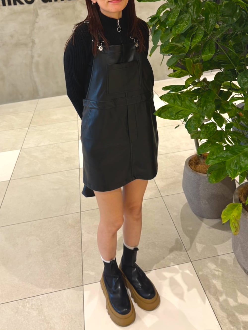 ブラック系のニット/セーター、ブラック系のオールインワン・サロペット、ブラック系のブーツを着用したレディースの冬コーディネートの2枚目の写真