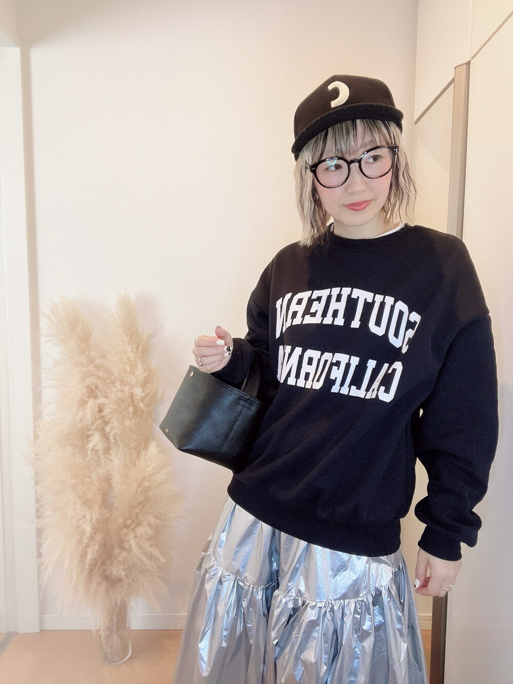 ブラック系のダウンジャケット/コート、ブラック系のスウェット、シルバー系のスカートを着用したレディースの冬コーディネートの2枚目の写真