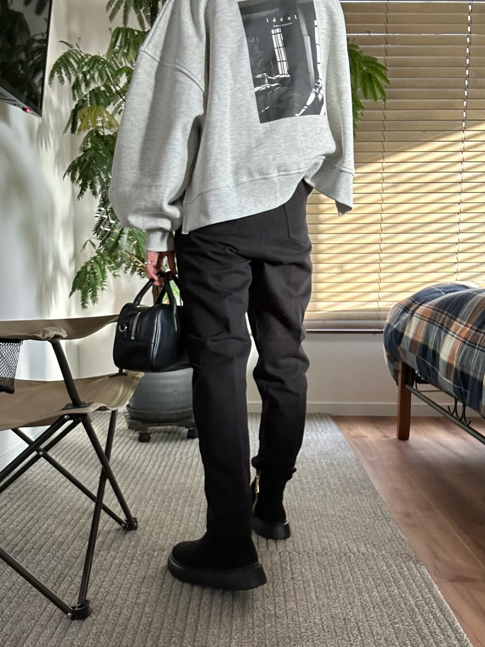 グレー系のTシャツ/カットソー、ブラック系のショルダーバッグ、ブラック系のデニムパンツを着用したレディースの冬コーディネートの2枚目の写真