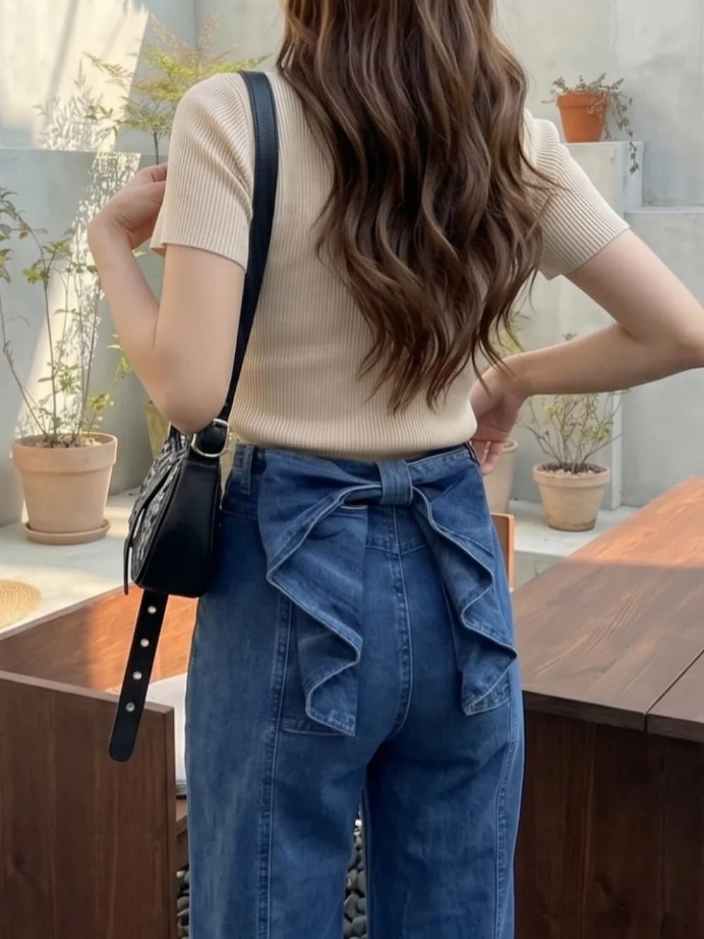 ブルー系のパンツ、ベージュ系のトップスを着用したレディースの夏コーディネートの2枚目の写真