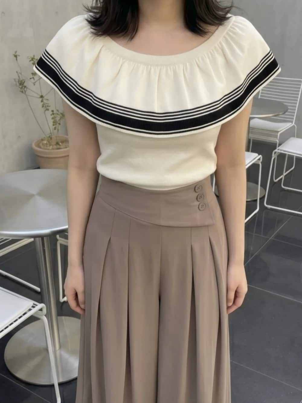 ブラウン系のパンツ、ホワイト系のトップスを着用したレディースの夏コーディネートの2枚目の写真