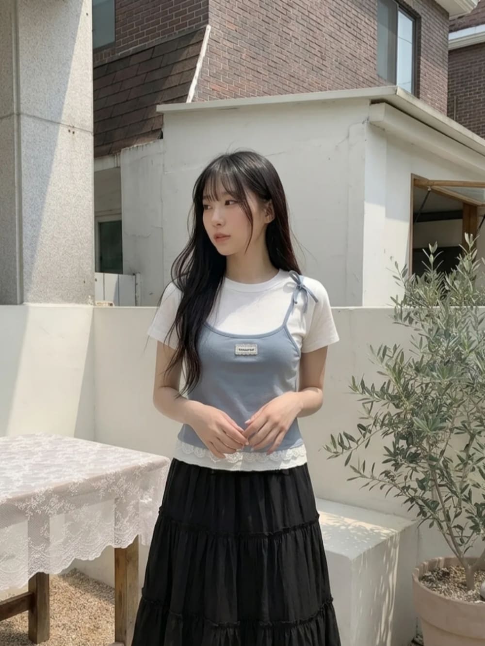 ブルー系のトップス、ブラック系のスカートを着用したレディースの夏コーディネートの2枚目の写真