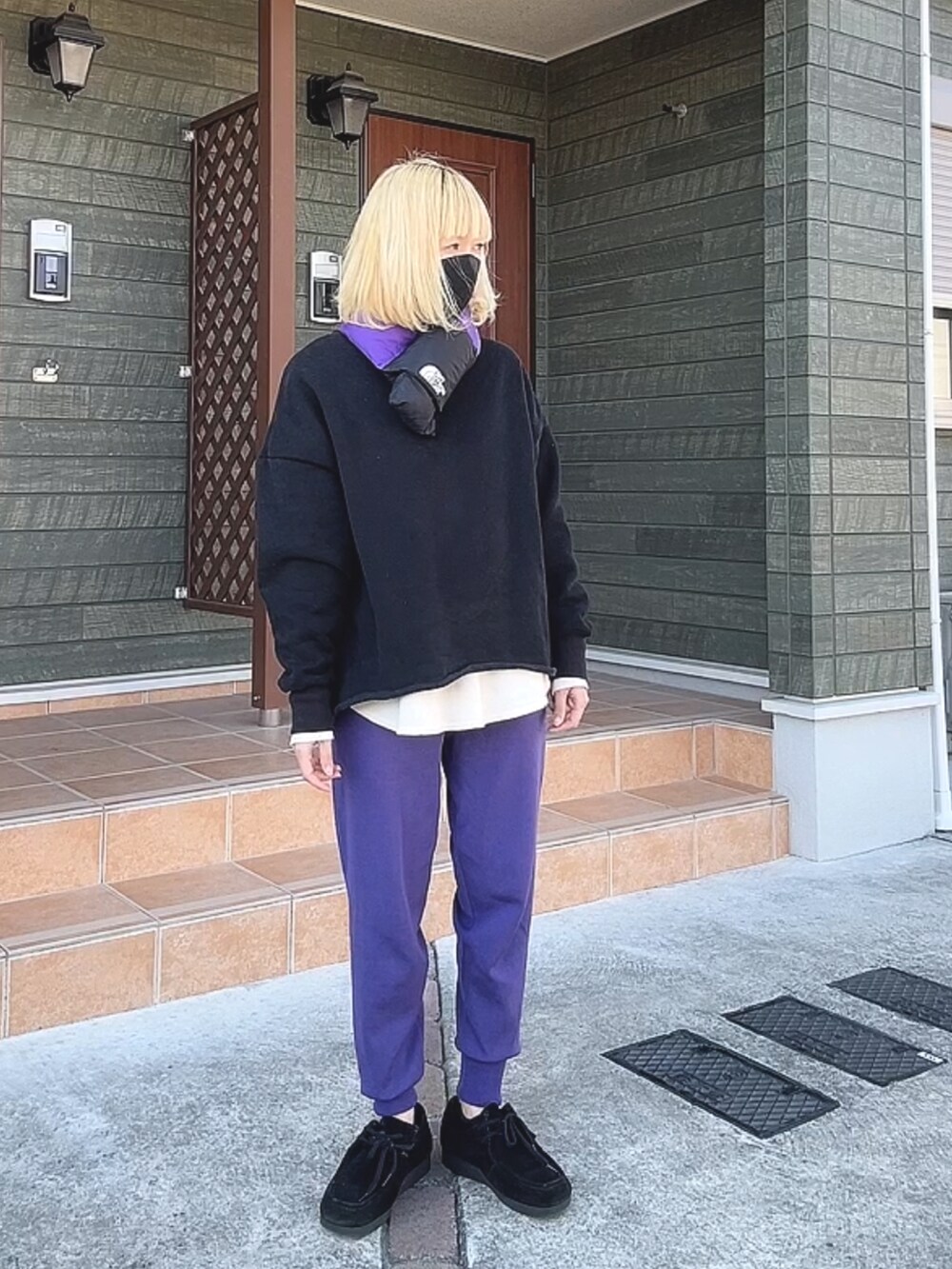 ブラック系のスウェット、ホワイト系のトップス、パープル系のその他パンツを着用したレディースの冬コーディネートの2枚目の写真