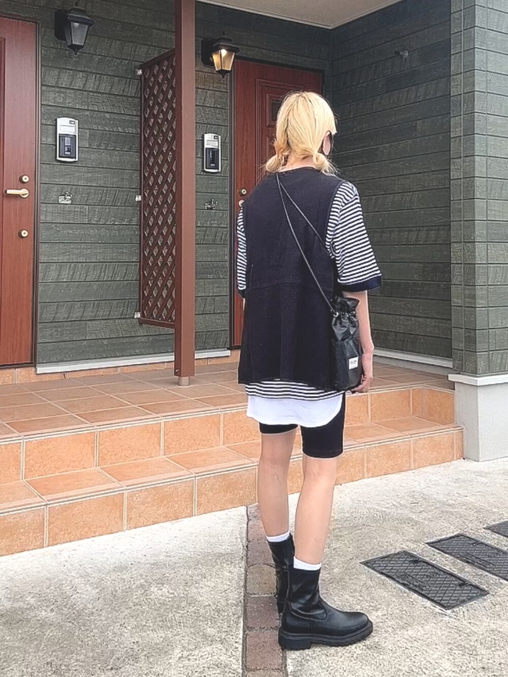 ブルー系のトップス、ホワイト系のベスト、ブラック系のパンツを着用したレディースの秋コーディネートの3枚目の写真