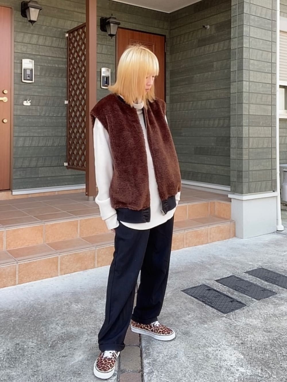 ブラック系のベスト、ベージュ系のTシャツ/カットソー、ブラック系のスラックスを着用したレディースの冬コーディネートの3枚目の写真