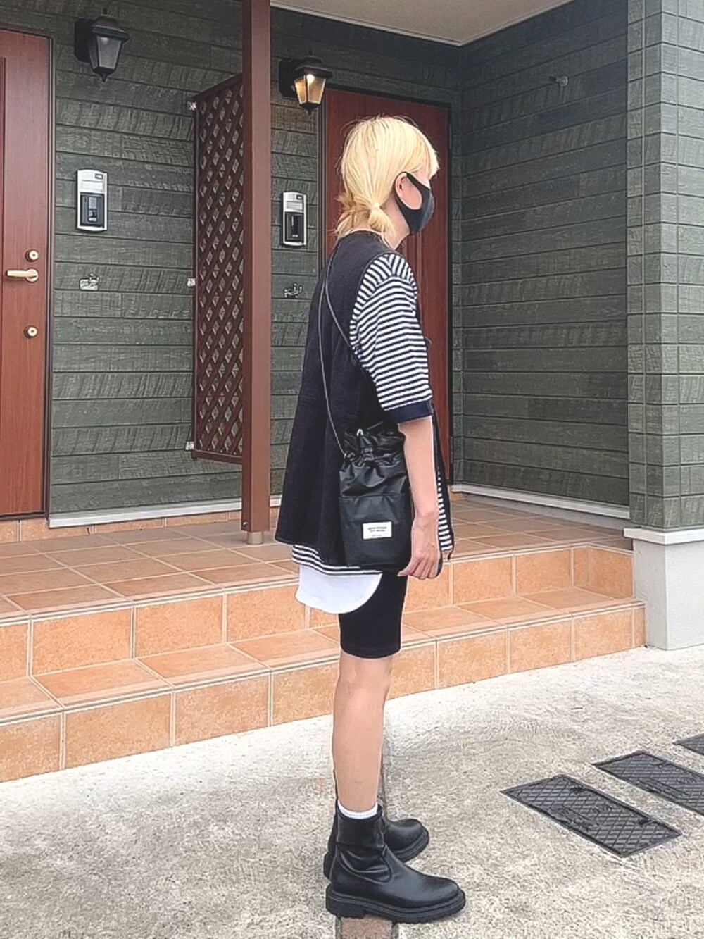 ブルー系のトップス、ホワイト系のベスト、ブラック系のパンツを着用したレディースの秋コーディネートの2枚目の写真