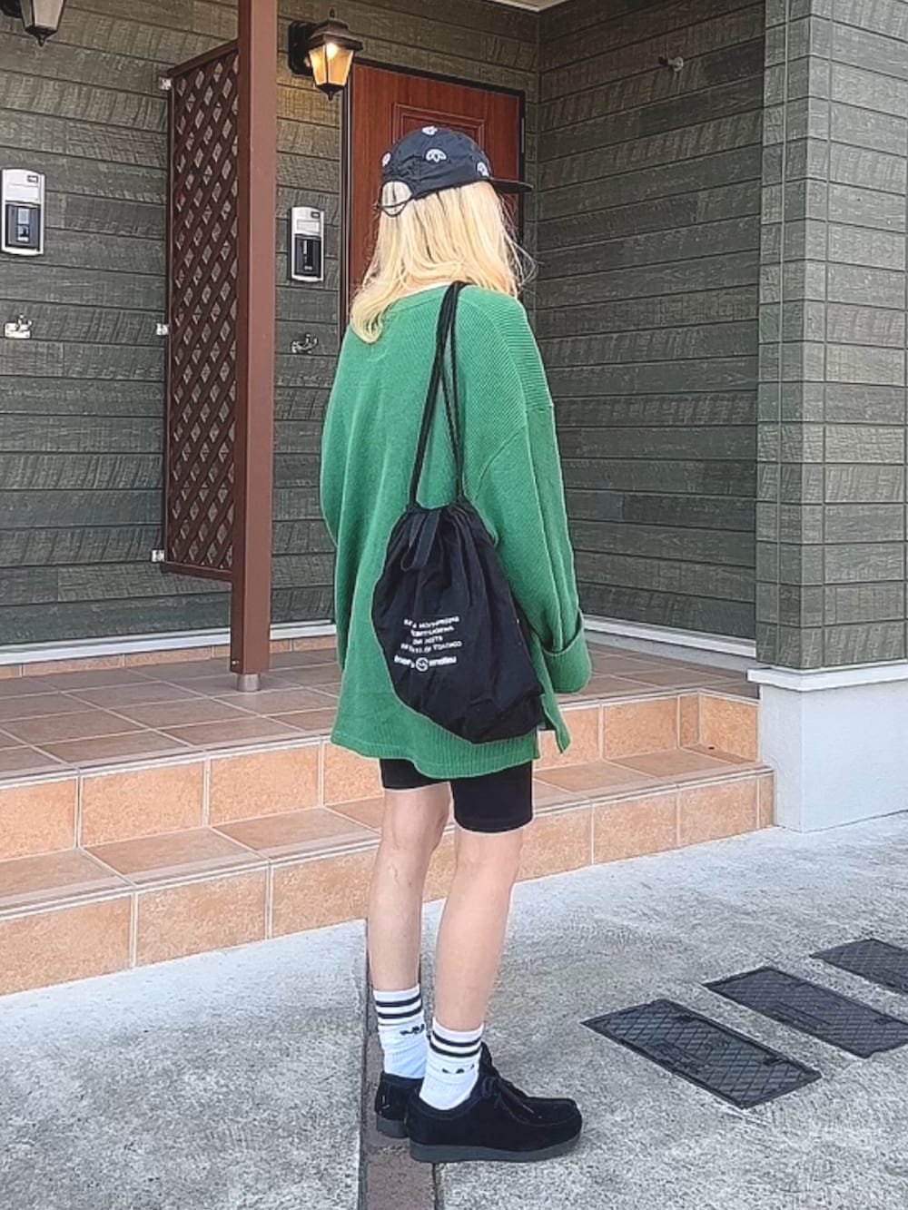 ブラック系のパンツ、ブラック系のシューズ、ブラック系のキャップを着用したレディースの秋コーディネートの2枚目の写真