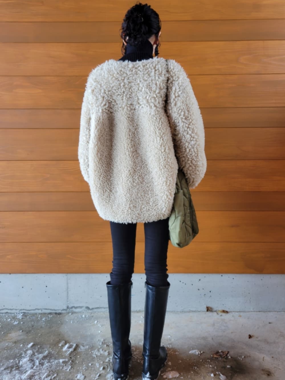 ベージュ系のその他アウター、ブラック系のニット/セーター、グリーン系のショルダーバッグを着用したレディースの冬コーディネートの2枚目の写真