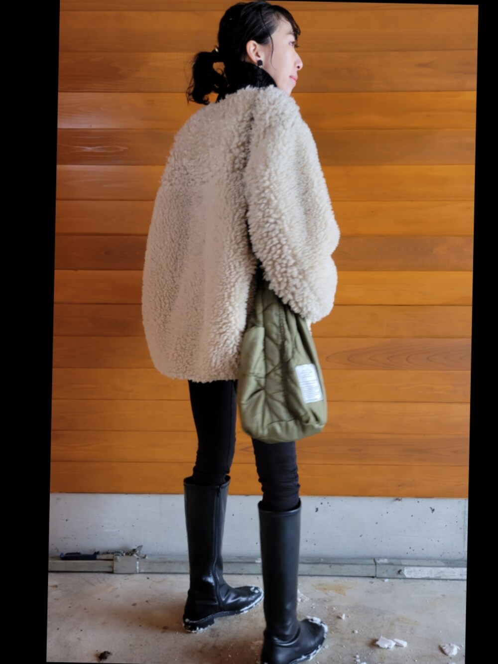 ベージュ系のその他アウター、ブラック系のニット/セーター、グリーン系のショルダーバッグを着用したレディースの冬コーディネートの3枚目の写真