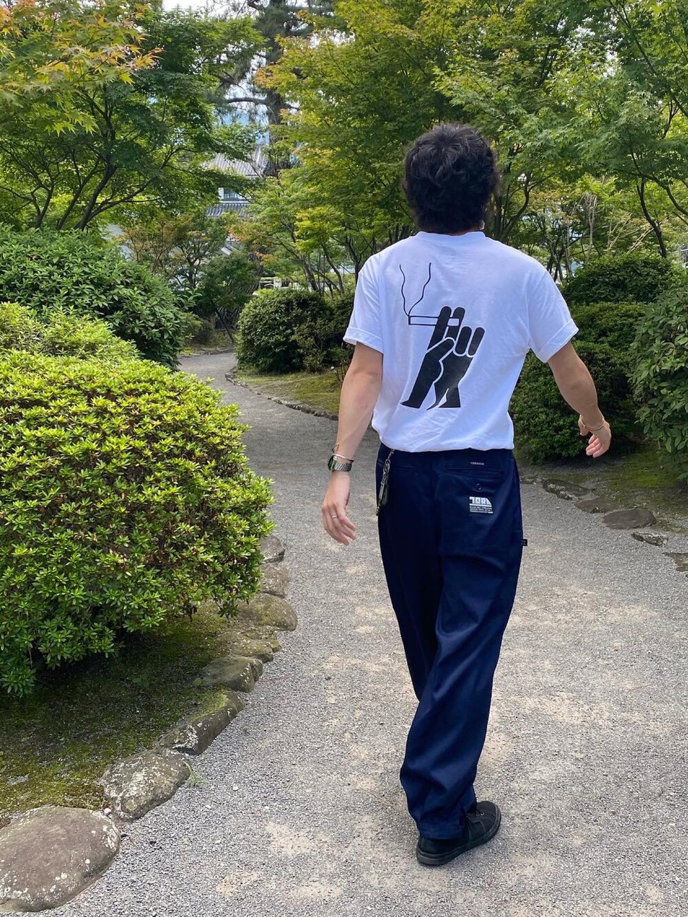 ブラック系のスニーカー、ブルー系のパンツ、ホワイト系のTシャツ/カットソーを着用したメンズの夏コーディネートの2枚目の写真