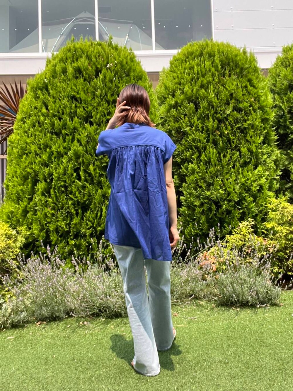 ブルー系のデニムパンツ、イエロー系のトートバッグ、ブラウン系のサンダルを着用したレディースの夏コーディネートの4枚目の写真