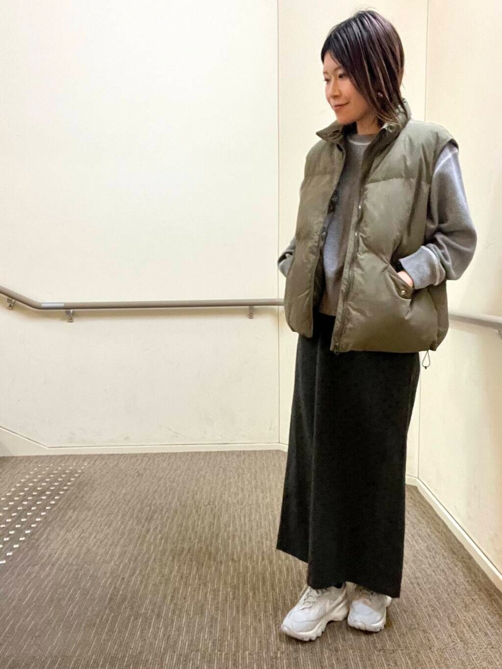 グレー系のスニーカー、グレー系のニット/セーター、グレー系のスカートを着用したレディースの冬コーディネートの4枚目の写真