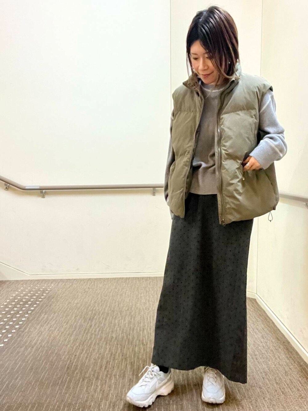 グレー系のスニーカー、グレー系のニット/セーター、グレー系のスカートを着用したレディースの冬コーディネートの3枚目の写真