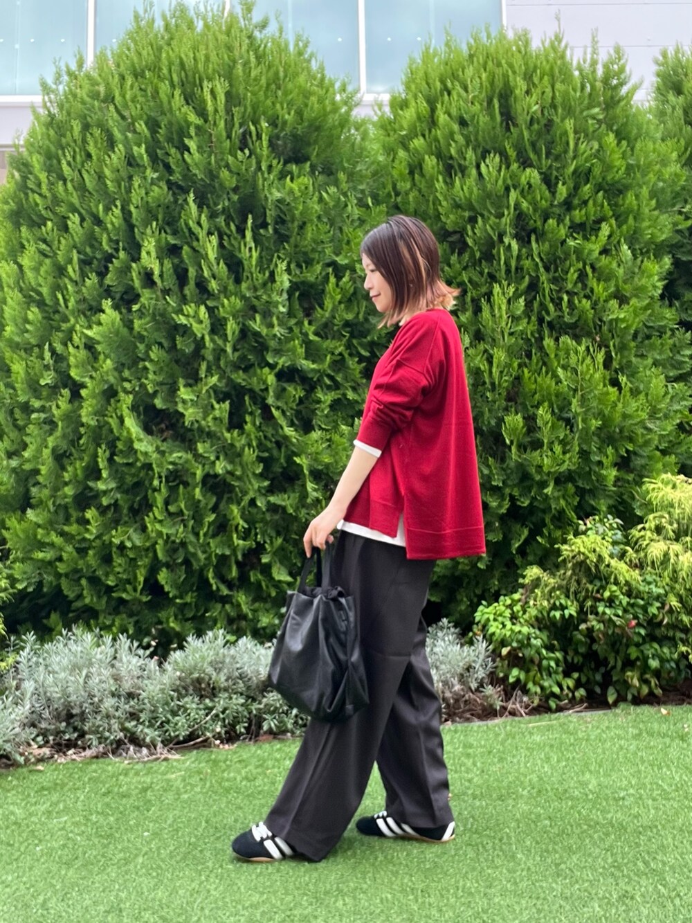 レッド系のニット/セーター、ホワイト系のTシャツ/カットソー、ブラック系のスニーカーを着用したレディースの秋コーディネートの5枚目の写真