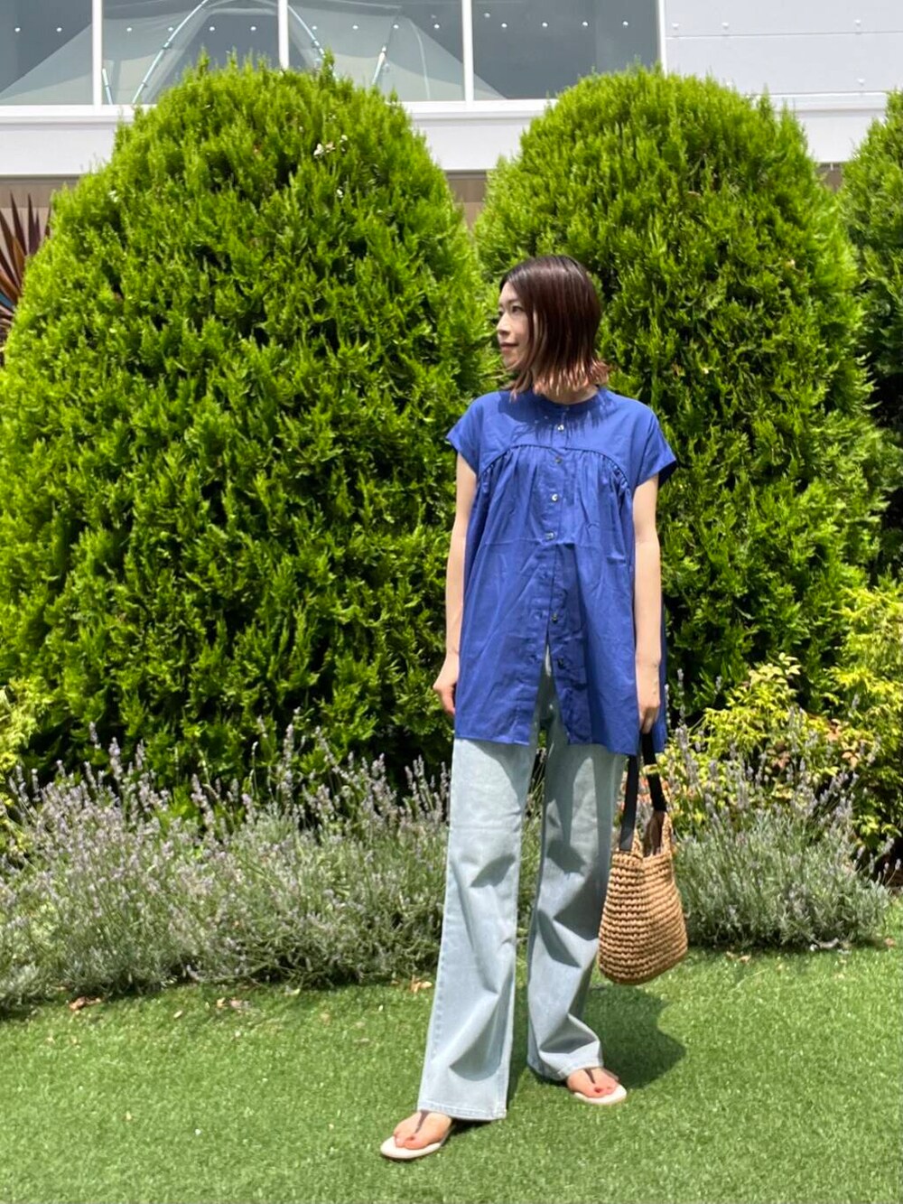 ブルー系のデニムパンツ、イエロー系のトートバッグ、ブラウン系のサンダルを着用したレディースの夏コーディネートの6枚目の写真