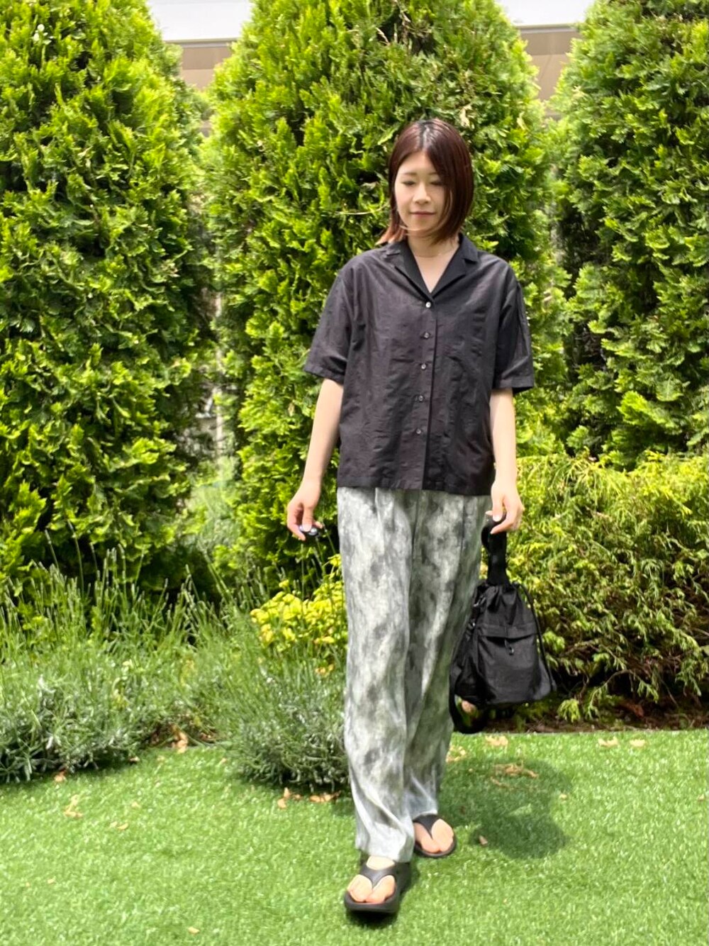 ブラック系のショルダーバッグ、ブラック系のサンダル、ブラック系のシャツ/ブラウスを着用したレディースの春コーディネートの6枚目の写真