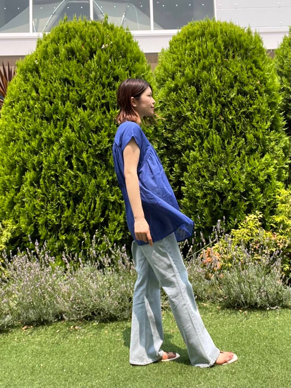 ブルー系のデニムパンツ、イエロー系のトートバッグ、ブラウン系のサンダルを着用したレディースの夏コーディネートの5枚目の写真