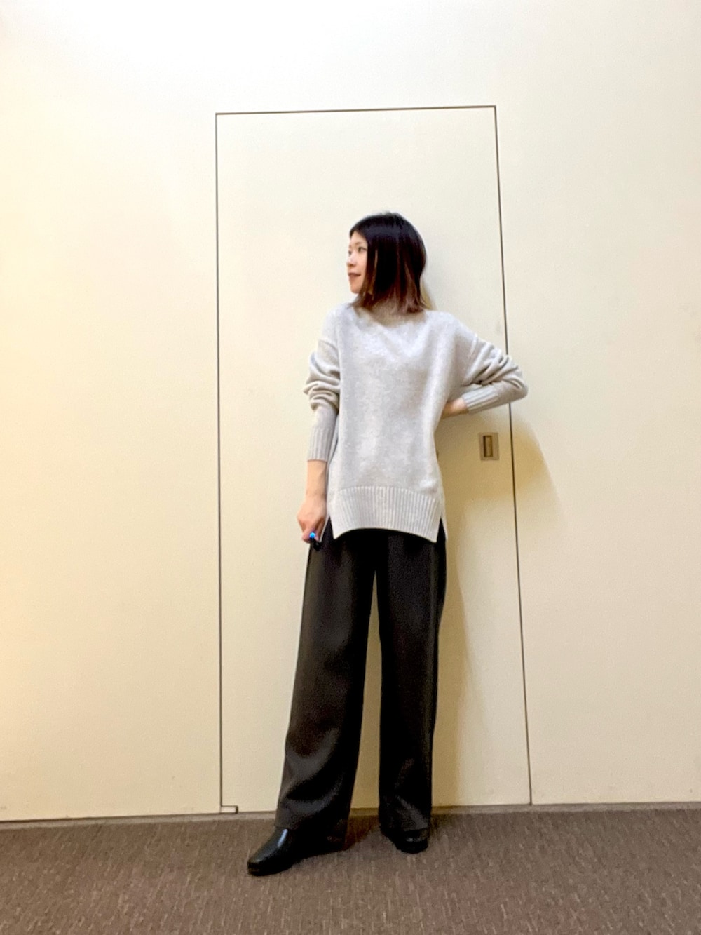 グリーン系のニット/セーター、グレー系のその他パンツ、ブラック系のブーツを着用したレディースの冬コーディネートの2枚目の写真