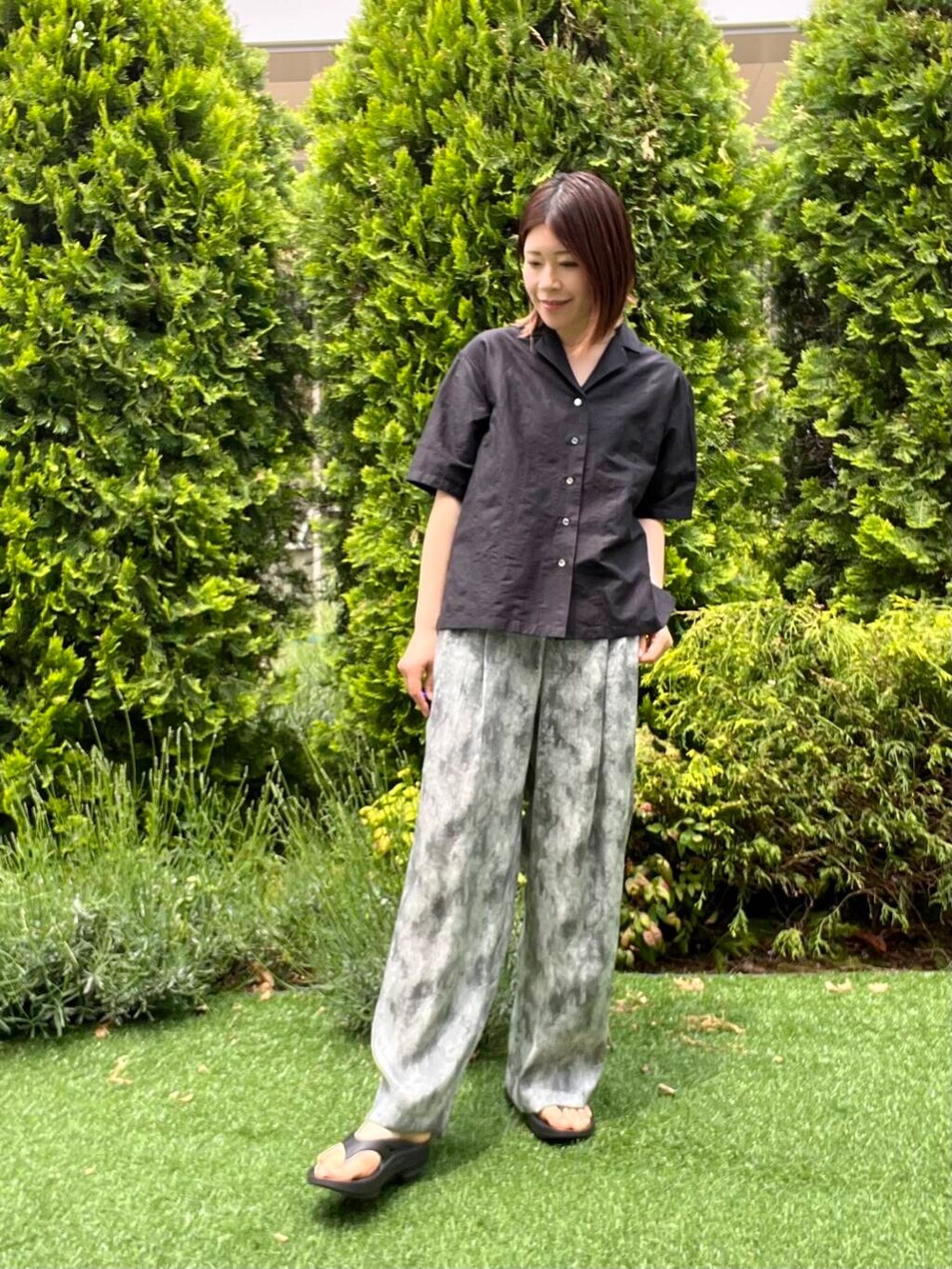 ブラック系のショルダーバッグ、ブラック系のサンダル、ブラック系のシャツ/ブラウスを着用したレディースの春コーディネートの2枚目の写真