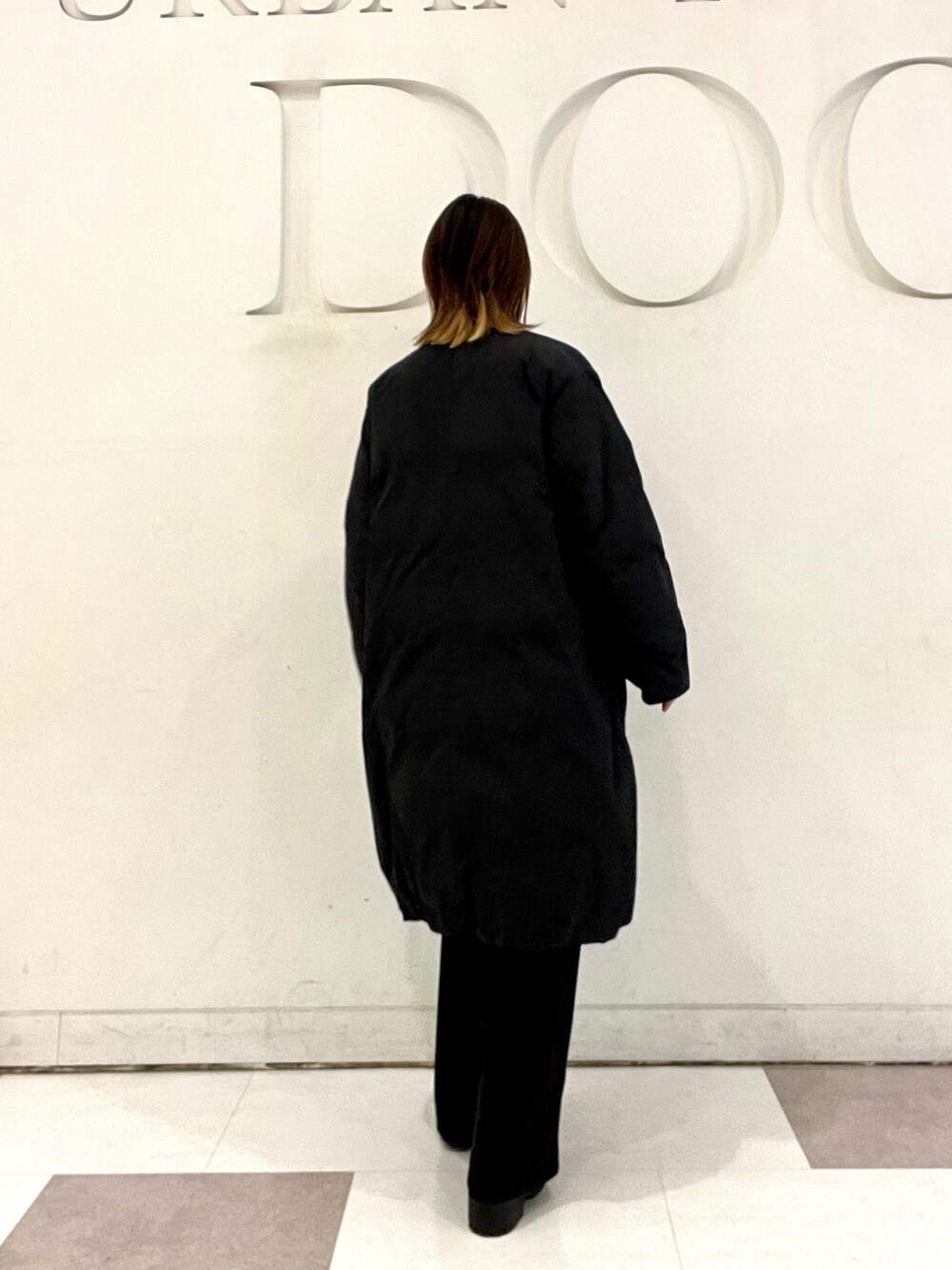 ブラック系のその他アウター、ブラック系のその他パンツ、ブラック系のブーツを着用したレディースの冬コーディネートの4枚目の写真