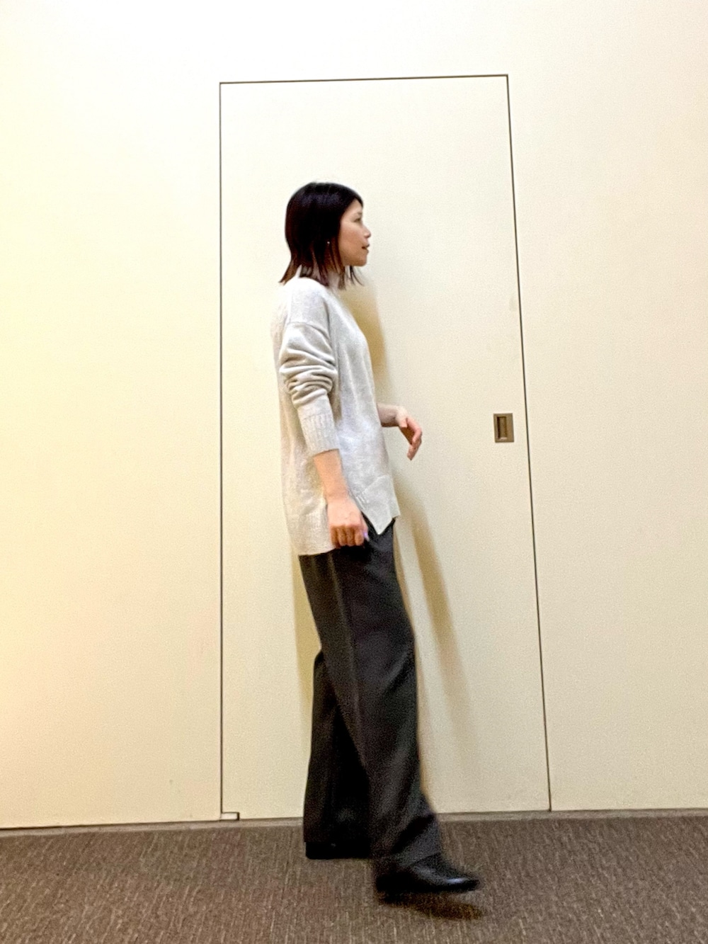 グリーン系のニット/セーター、グレー系のその他パンツ、ブラック系のブーツを着用したレディースの冬コーディネートの4枚目の写真