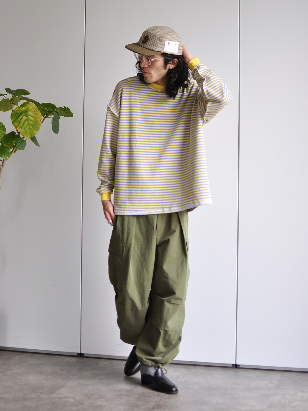 グリーン系のカーゴパンツ、イエロー系のTシャツ/カットソー、ブラック系のサンダルを着用したメンズの春コーディネートの2枚目の写真