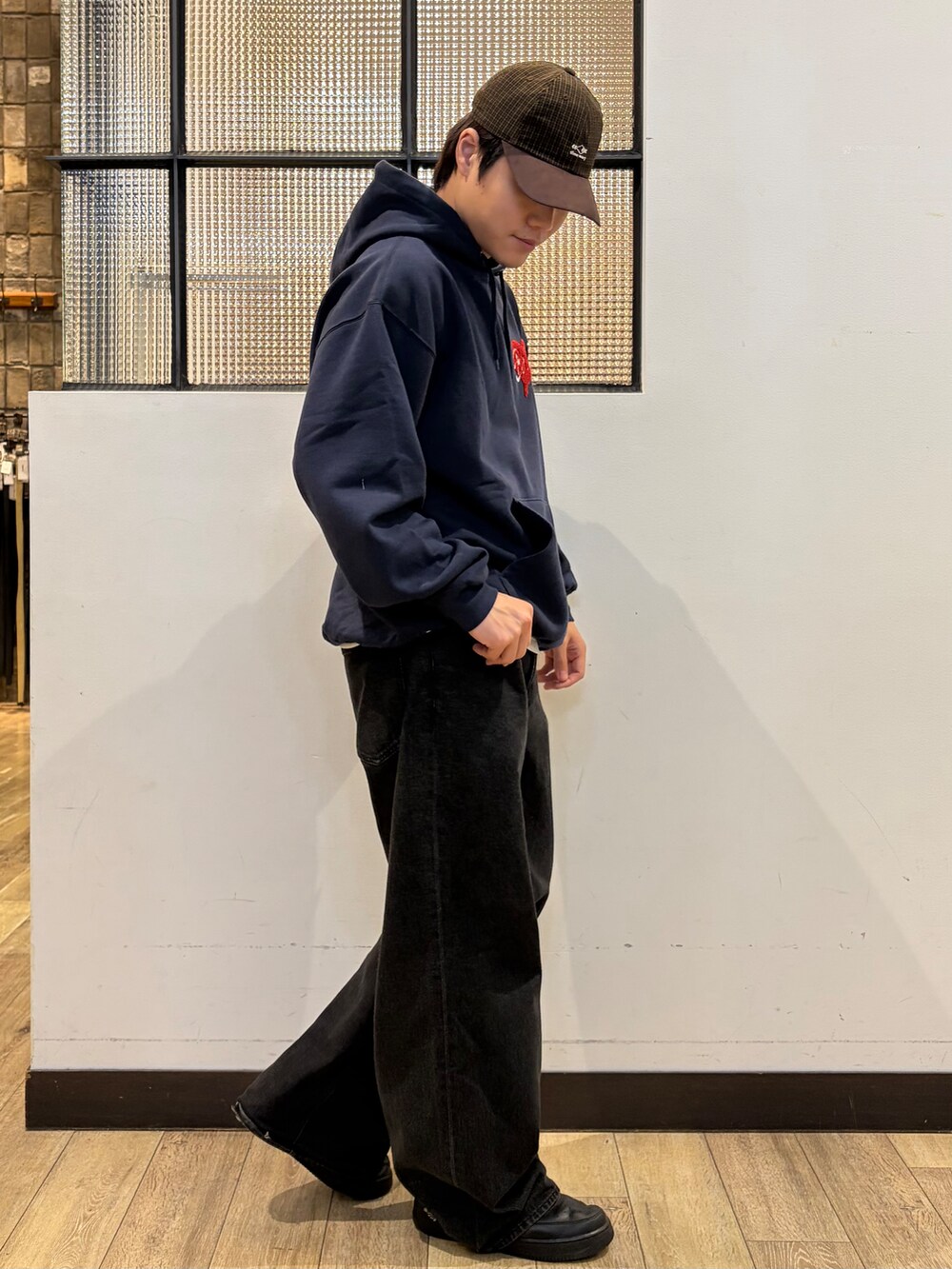 ブルー系のTシャツ/カットソー、ホワイト系のTシャツ/カットソー、ブラウン系のキャップを着用したメンズの秋コーディネートの4枚目の写真