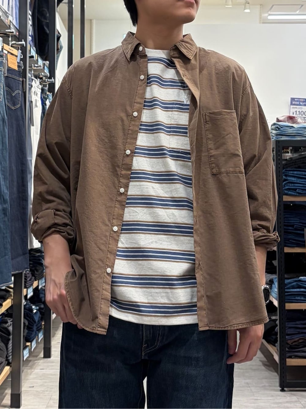 ブラウン系のシャツ/ブラウス、ホワイト系のTシャツ/カットソー、ブルー系のデニムパンツを着用したメンズの春コーディネートの5枚目の写真