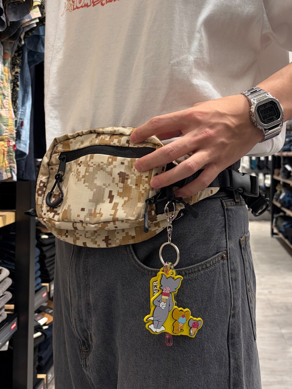 ブラック系のデニムパンツ、ホワイト系のTシャツ/カットソー、ベージュ系のボディバッグ/ウエストポーチを着用したメンズの夏コーディネートの6枚目の写真