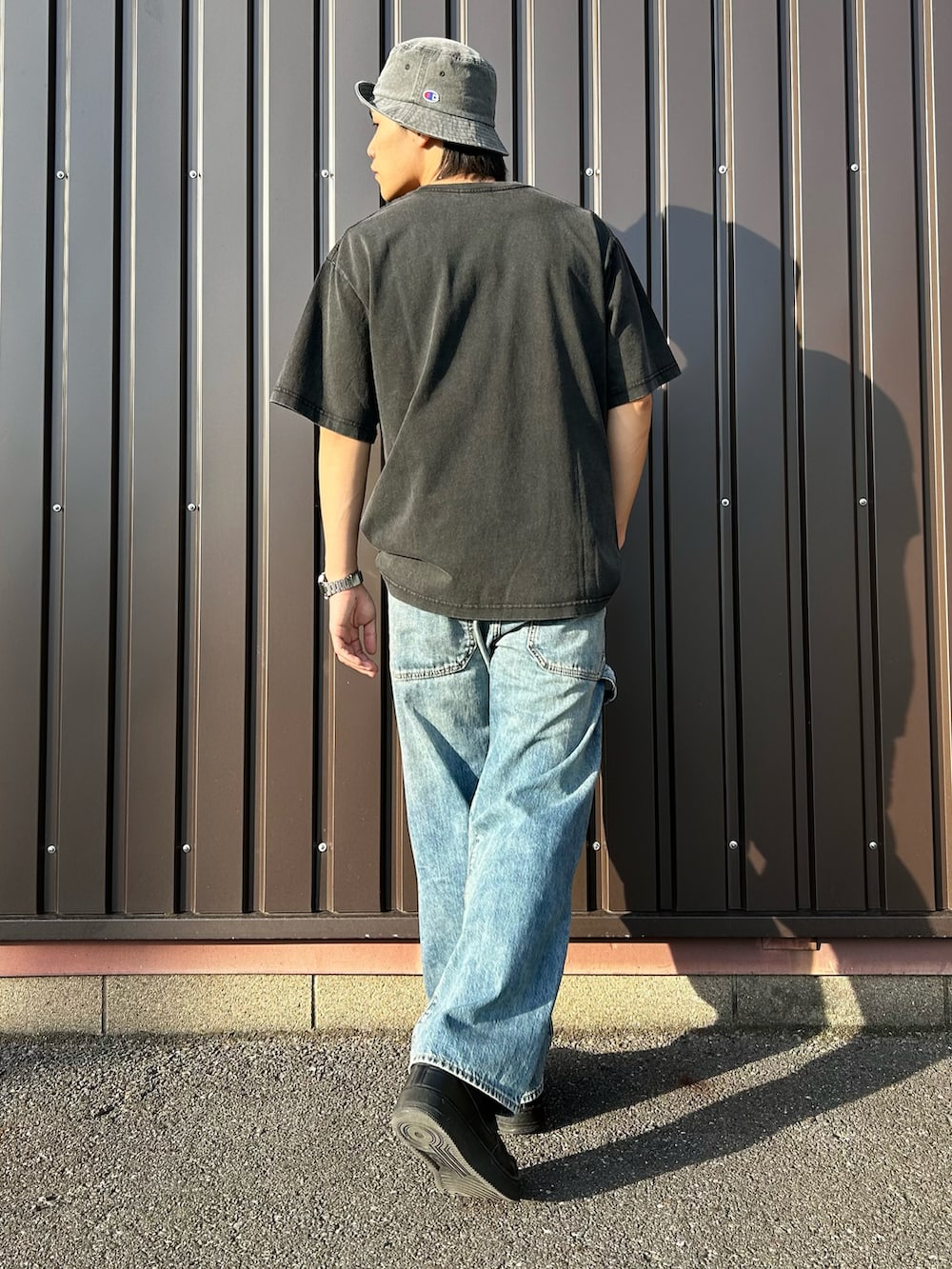 ブラック系のTシャツ/カットソー、ブルー系のデニムパンツを着用したメンズの春コーディネートの4枚目の写真
