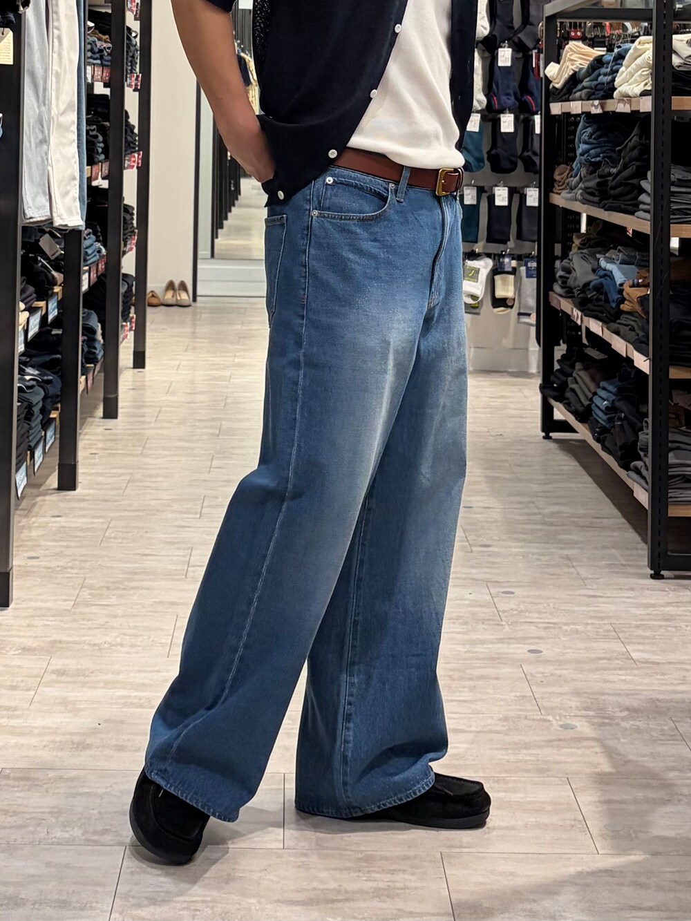 ブルー系のデニムパンツ、ブルー系のニット/セーター、ブラウン系のベルトを着用したメンズの夏コーディネートの8枚目の写真